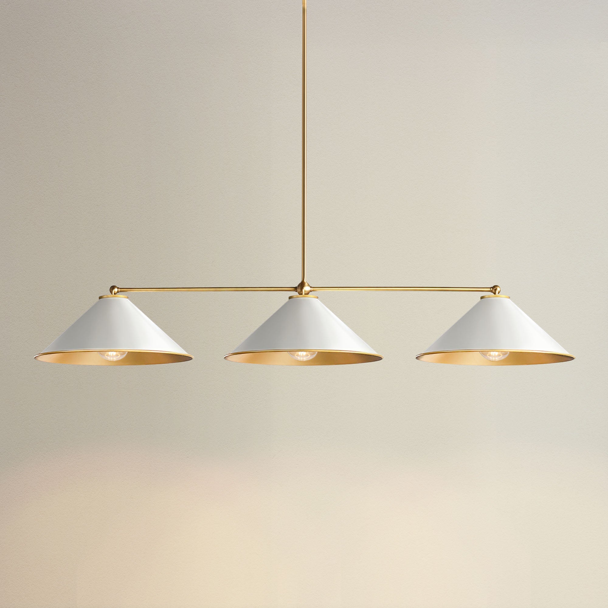 liora three light pendant with three white lampshades and gold accents, on