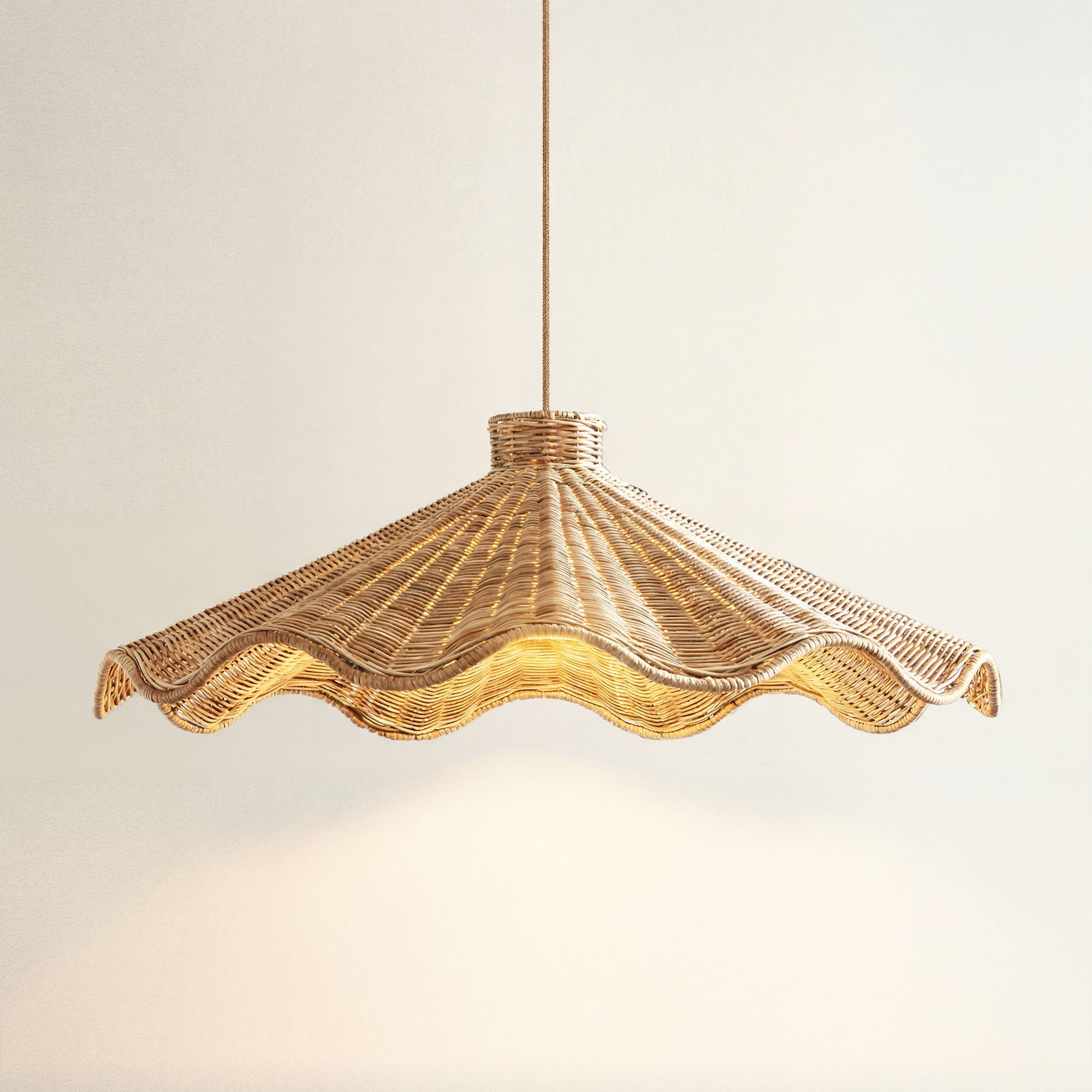 cover ariel woven rattan pandent light with a scalloped edge, on