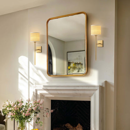 luma rattan sconce for living room with gold-framed mirror with wall lights on either side