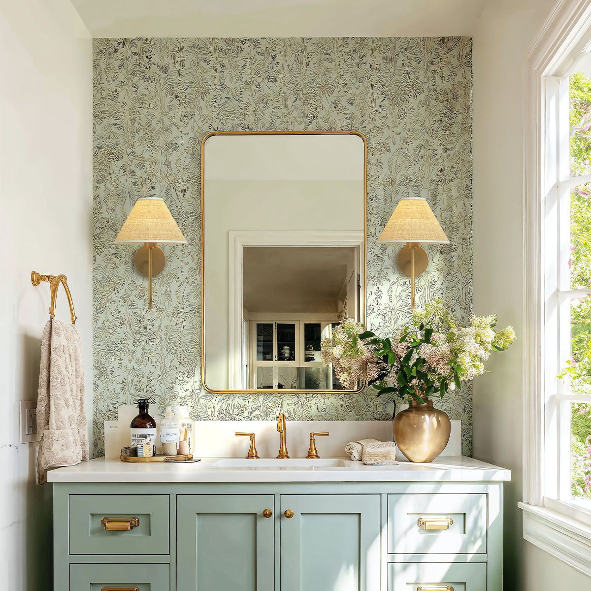 mysa rattan sconce bathroom with green floral wallpaper and vanity