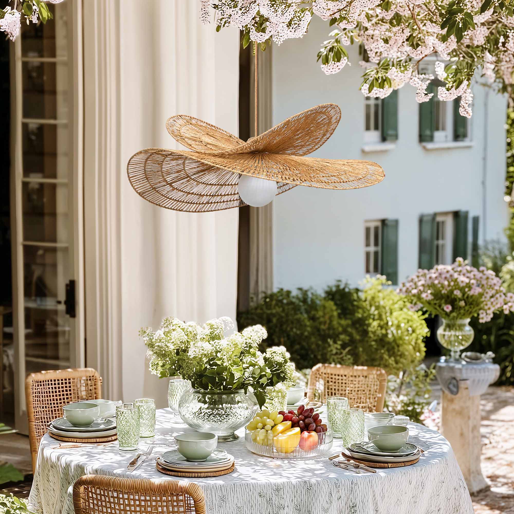outdoor whisper leaf pendant light for dining table setting with flowers, fruit, and a decorative ceiling light