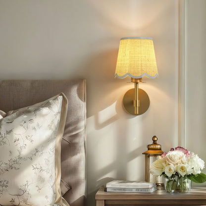 solenne clamp rattan sconce for bedroom casting a warm glow on a nightstand