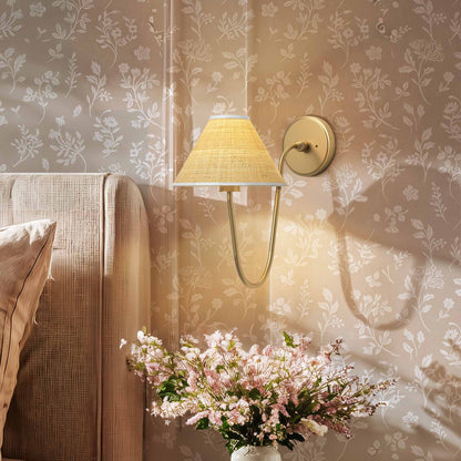 zoom soleil curve arm sconce for bedroom with floral arrangement against a patterned wall
